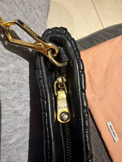 Miu Miu black leather clutch with long strap.