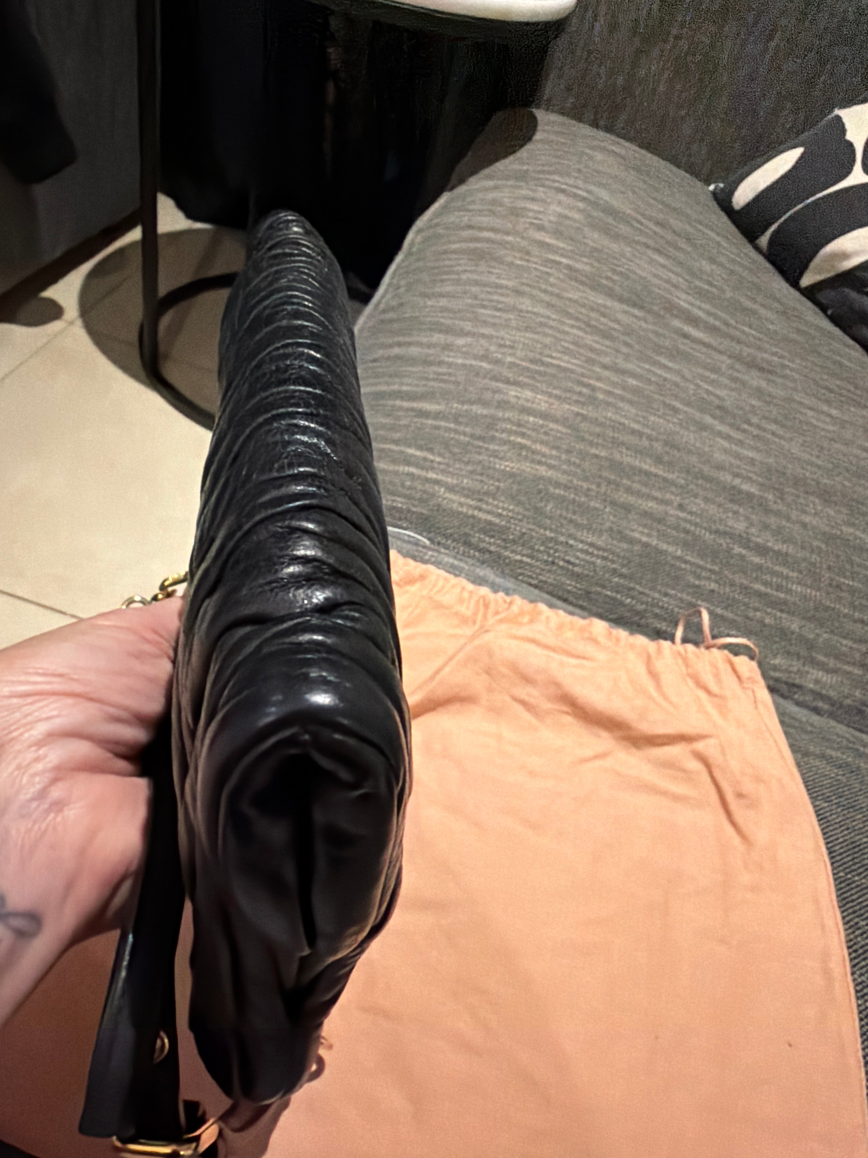 Miu Miu black leather clutch with long strap.