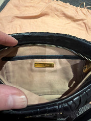 Miu Miu black leather clutch with long strap.