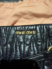 Miu Miu black leather clutch with long strap.